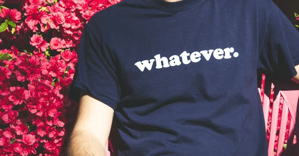 Fotografía de una persona que lleva una camiseta en la que pone "whatever" para ilustrar el JOMO contra el FOMO