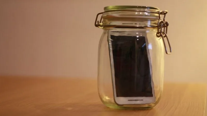 Fotografía de teléfono móvil metido en un bote de vidrio