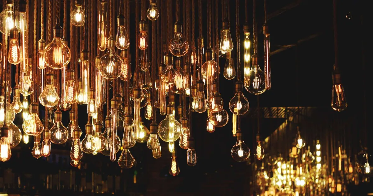 Fotografía de muchas bombillas distintas encendidas en la oscuridad.