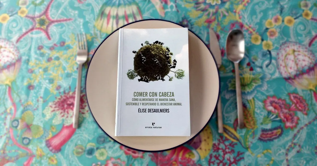 Fotografía del libro Comer con cabeza. Cómo alimentarse de manera sana, sostenible y respetando el bienestar animal publicado por Errata Naturae colocado sobre un plato