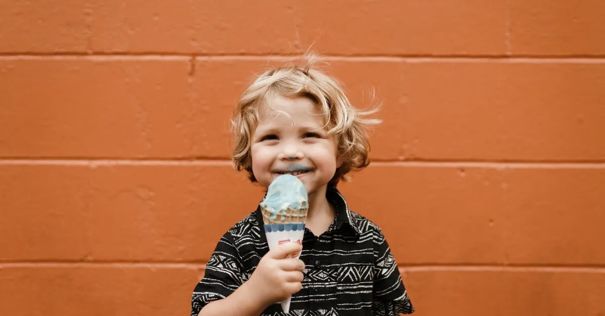 Un niño sonriente disfrutando de un helado.