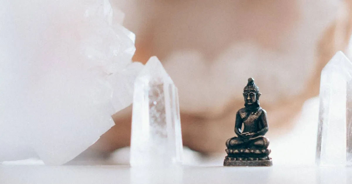 Fotografía de una escultura de Buda junto a unos cristales de cuarzo