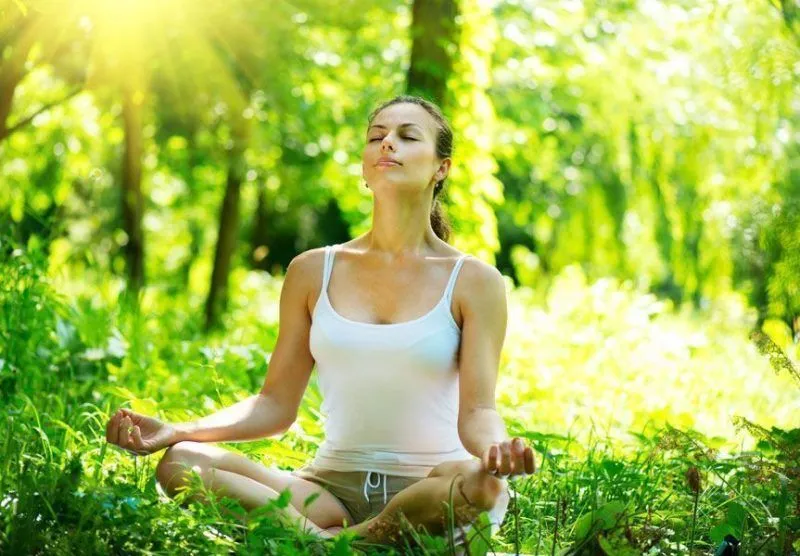 Mujer meditando con las piernas cruzadas en una mala postura de meditación.