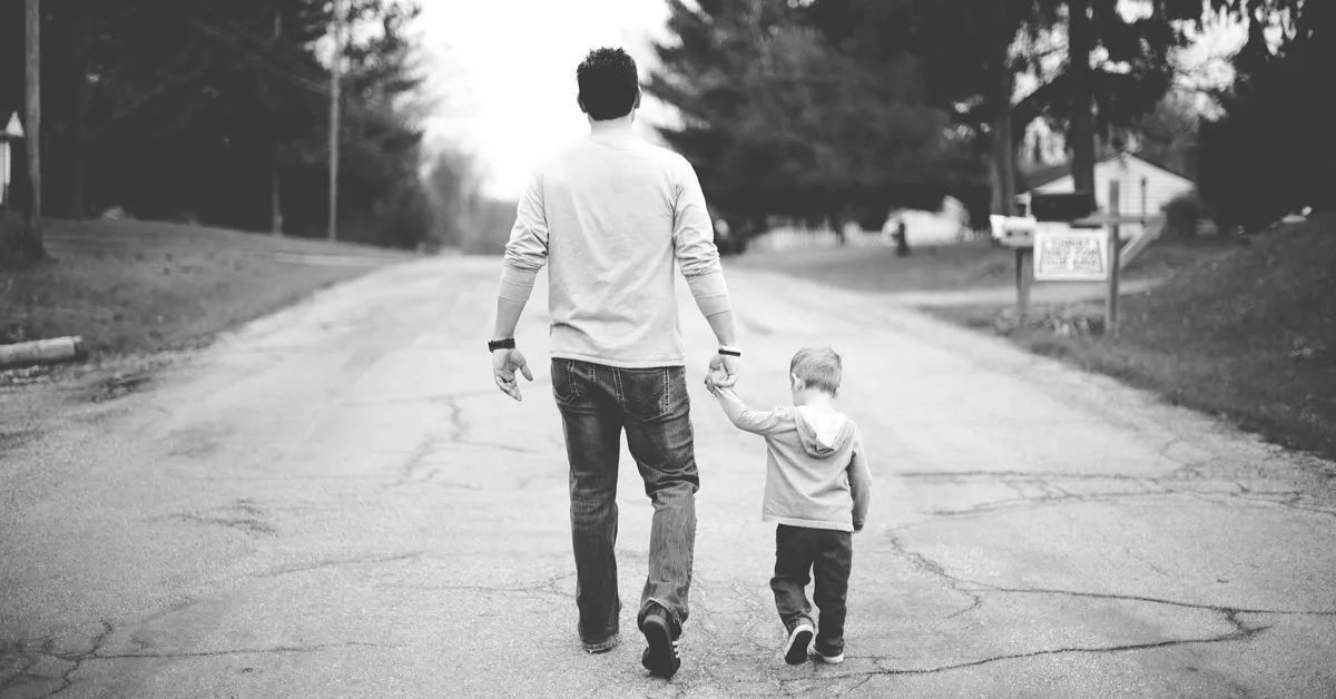 Fotografía de un hombre paseando con un niño pequeño