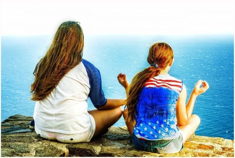 Dos chicas meditando en una pésima postura para meditar